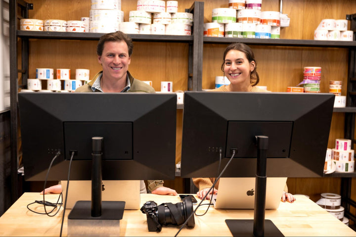 Compass Coffee CEO Michael Haft and Marketer Gabby Levy working on computers together 