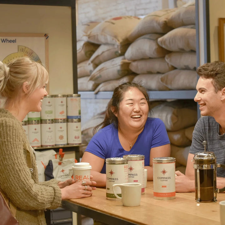 Friends enjoying a french press of Compass Coffee